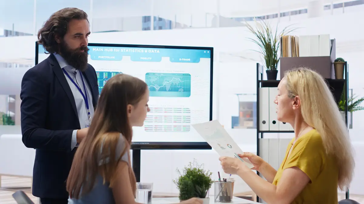 Agent teaching parent and daughter how to invest offering statistical graphs